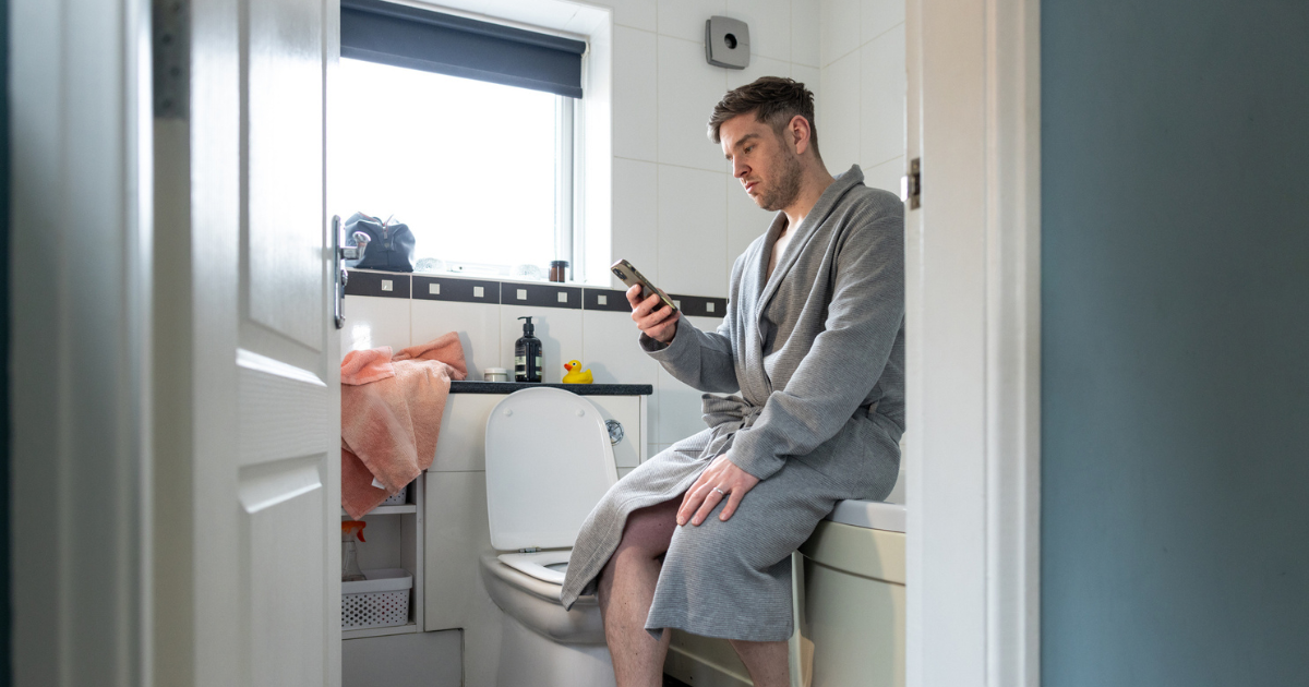Man on phone in bathroom