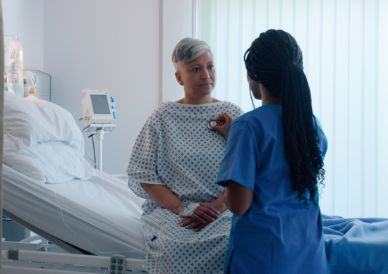 Nurse listening to woman's heart