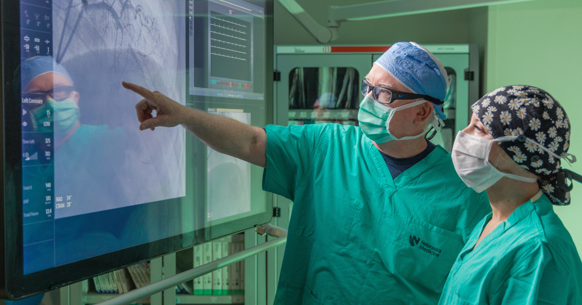 Dr. O'Leary pointing at cardiovascular image on screen with Kara Kendra on right