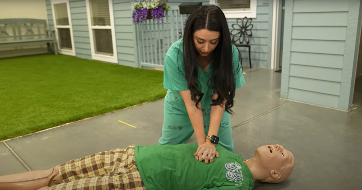 Woman performing chest compressions on a CPR dummy