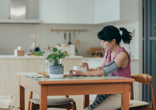 Woman checking blood pressure at home