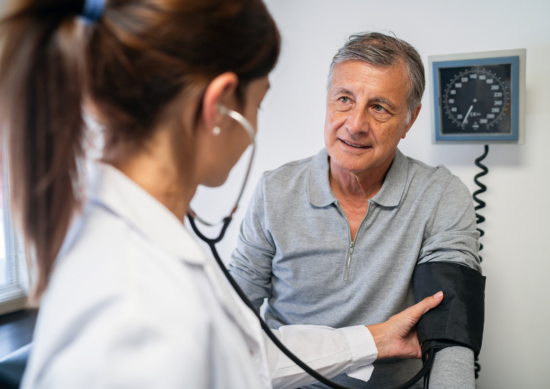 Provider taking man's blood pressure