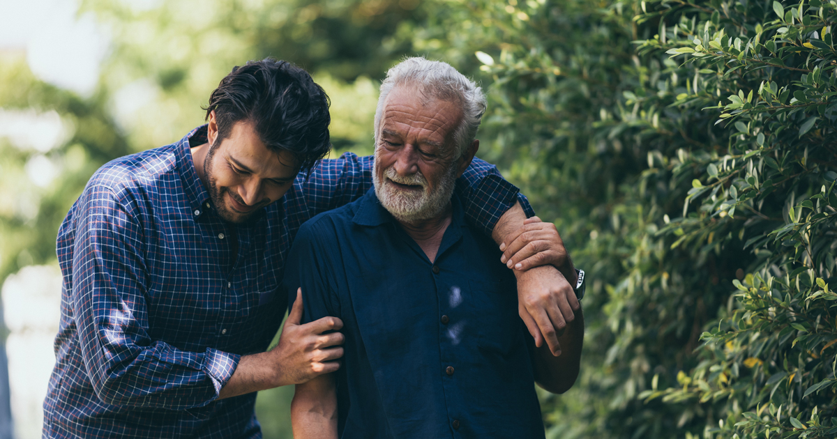 Man walking with his arm around his father