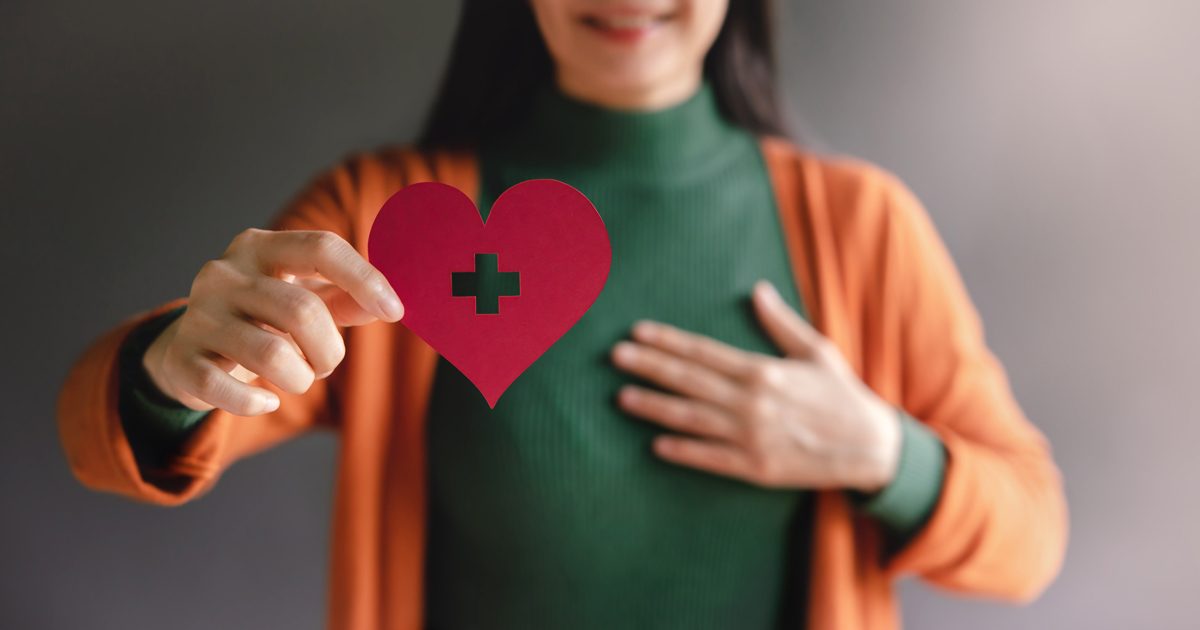 Woman holding paper cut out of a heart