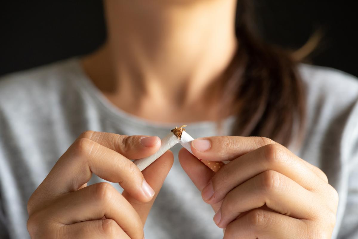 Woman breaking cigarette in half