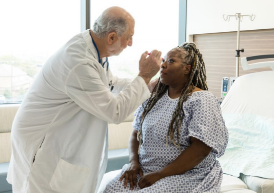 Doctor shining light in woman's eyes