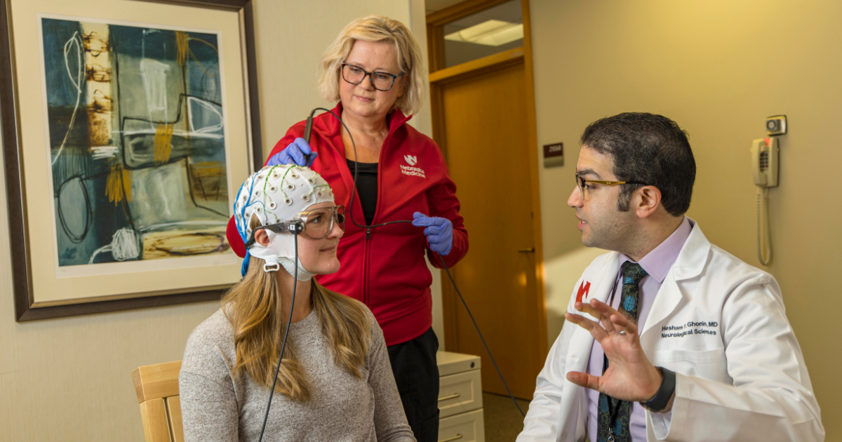 Doctor explaining procedure to patient with a medical cap