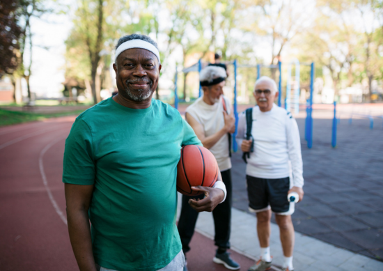 An old man is holding a basketball