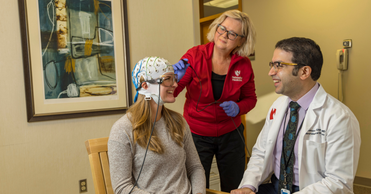 Doctor and nurse talking to patient with MEG helmet
