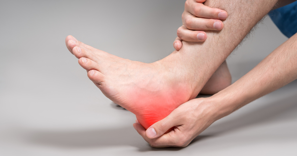 Close up of man holding his heel in pain