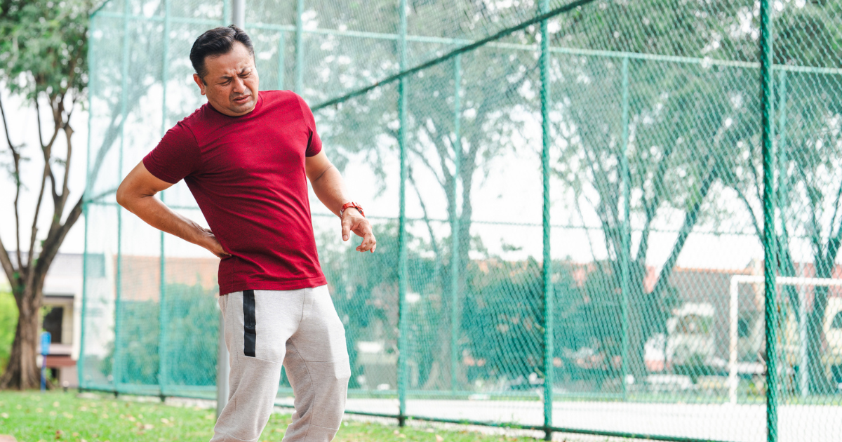 Man at park, holding hip in pain