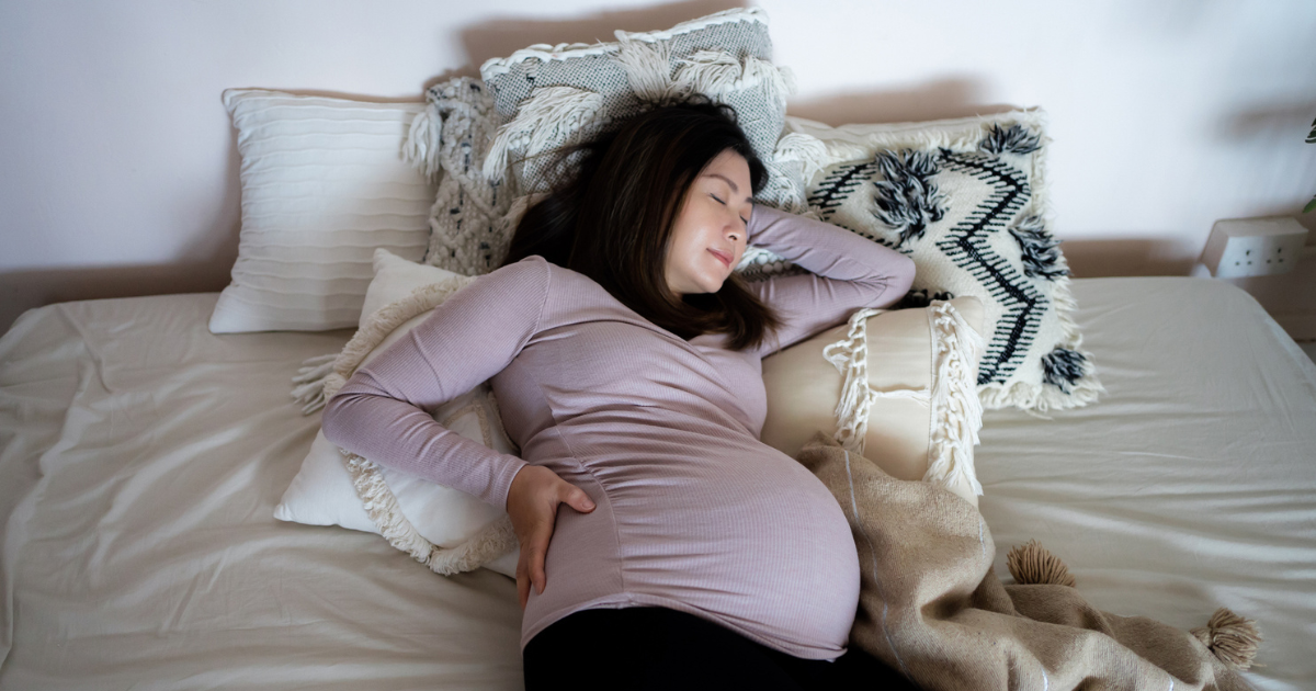 Pregnant woman laying in bed