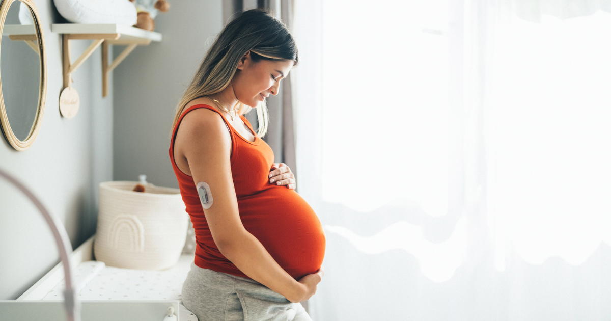 Pregnant woman wearing a glucose monitor