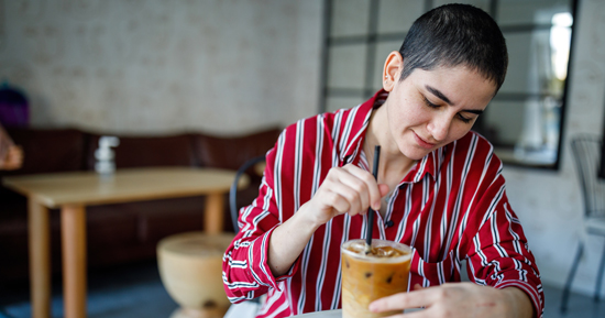 picture of a person stirring their pumpkin spice latte