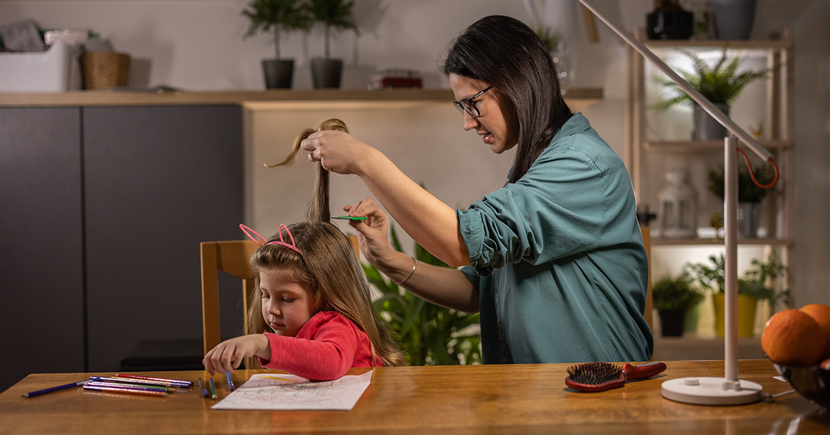 picture of a woman checking her daughter's hair for lice