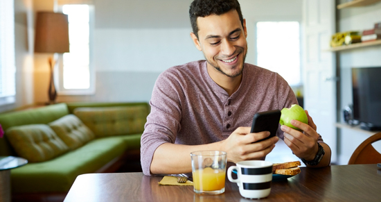 picture of a man eating and entering his macros in his phone app