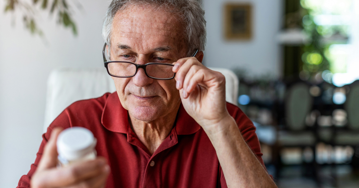 Man looking at pill bottle