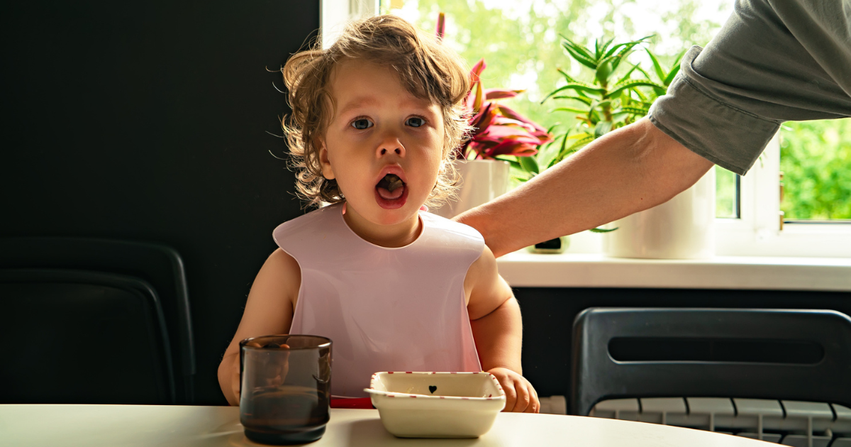 Little girl choking on food while dad pats her back