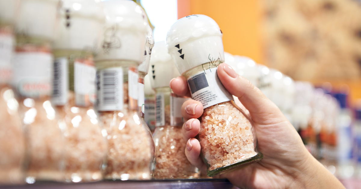 Woman grabbing Himalayan salt grinder off store shelf