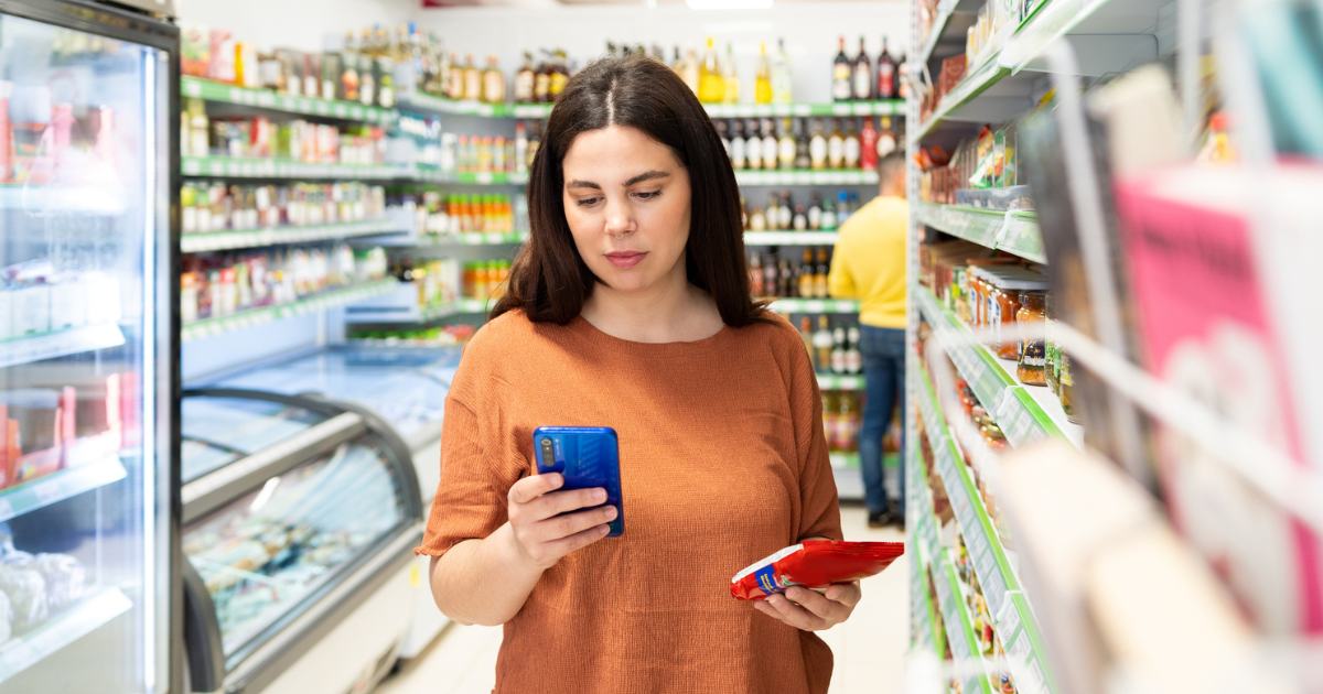 Woman in grocery store looking at her phone