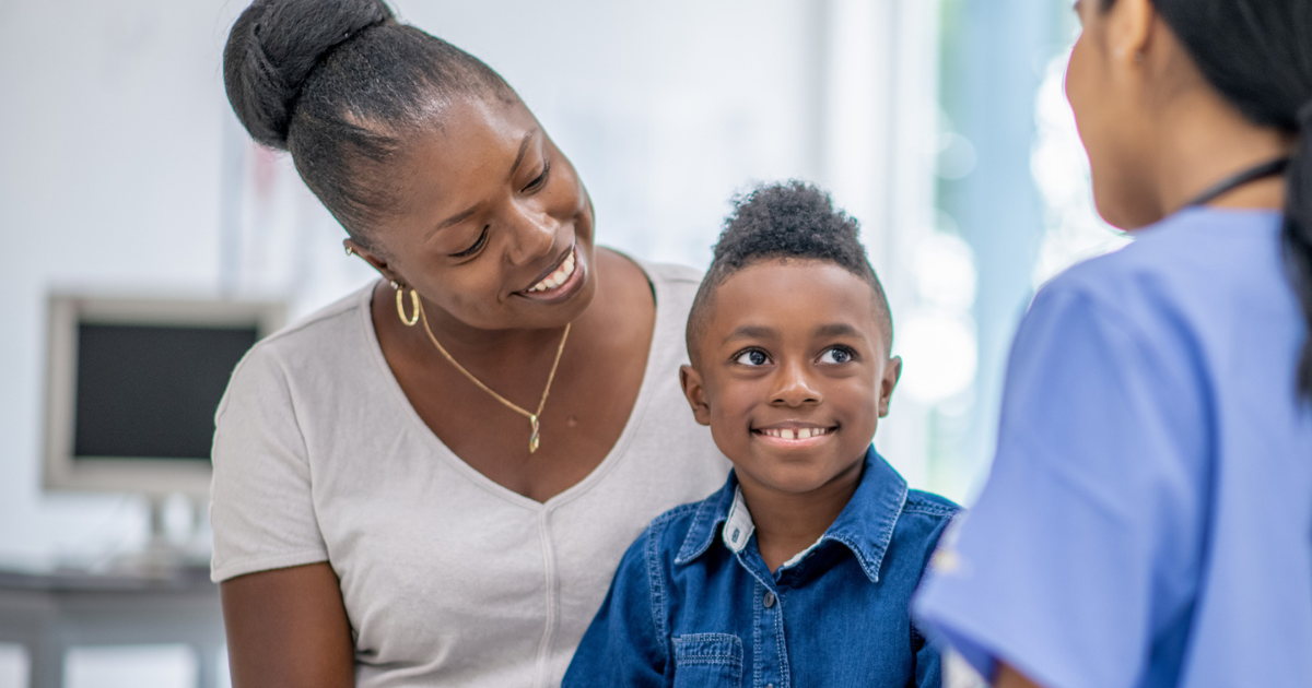 Mother and young son talking to provider in doctor's office