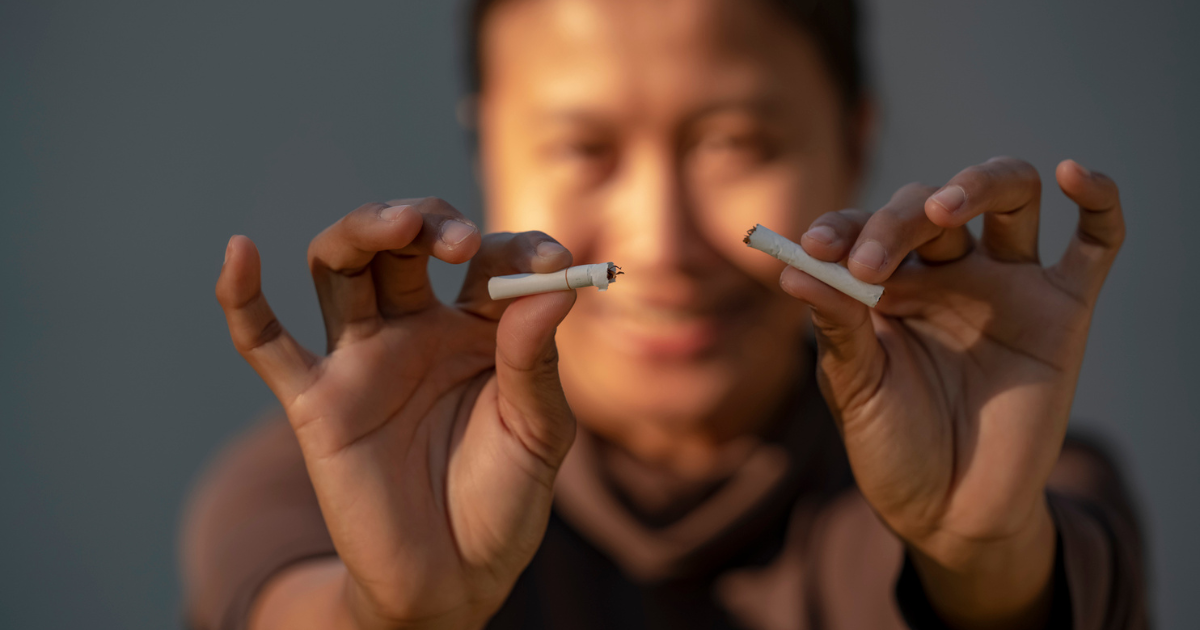 Woman breaking cigarette in half