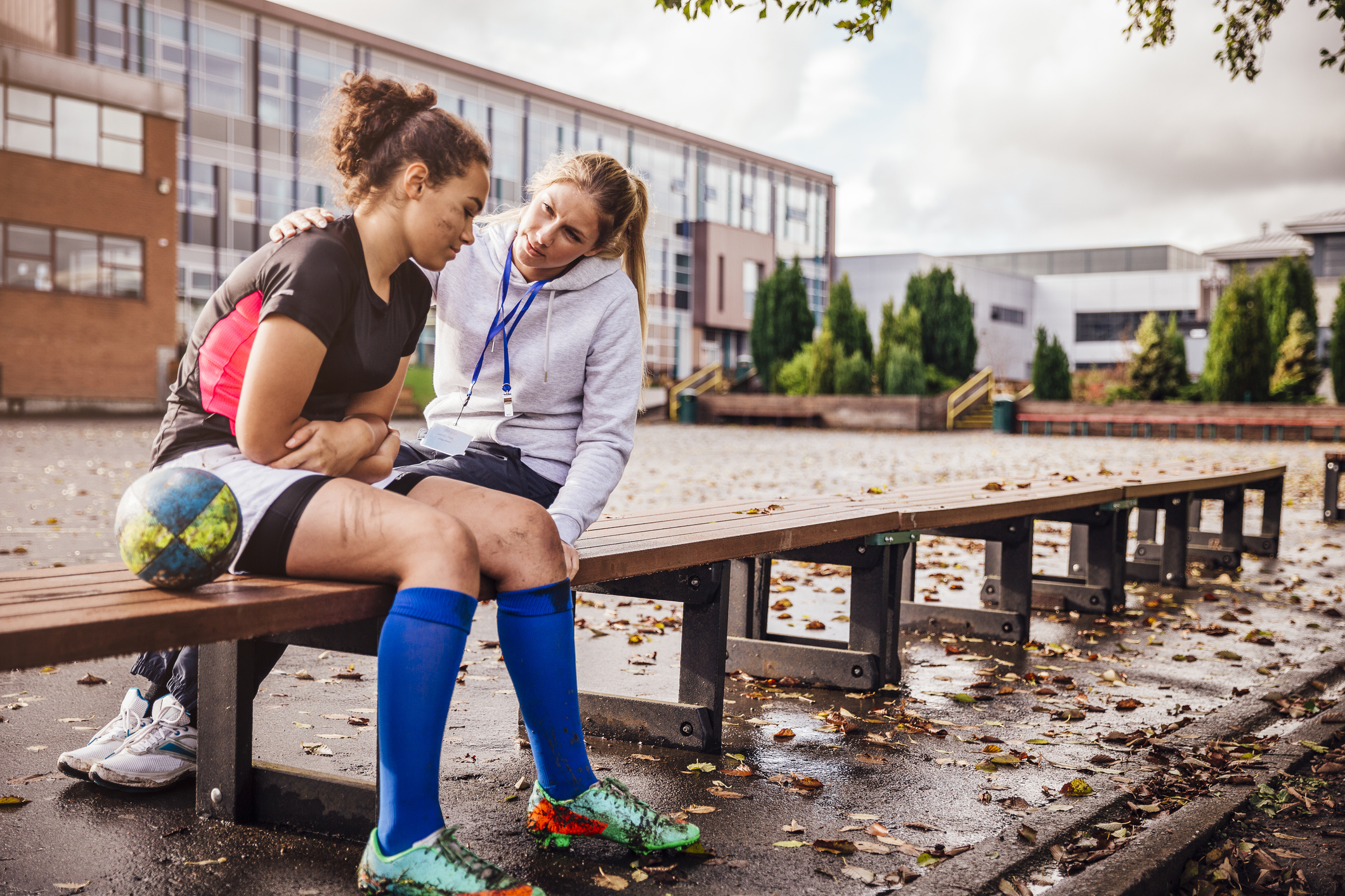 Rugby player sitting on bench with coach