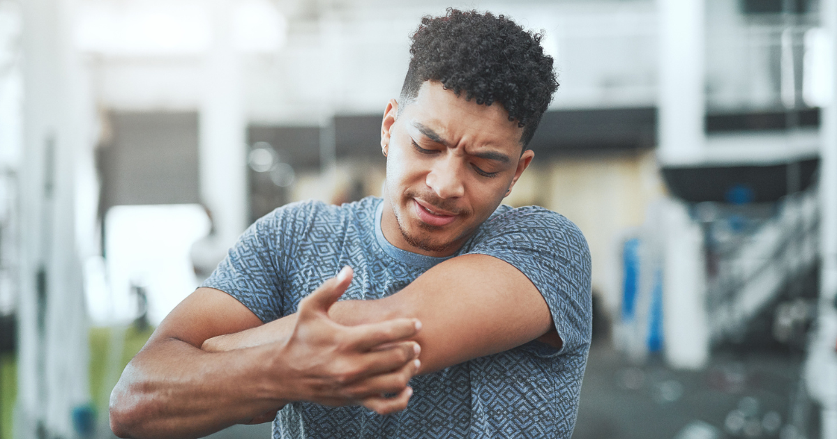 Man at the gym grabbing his elbow