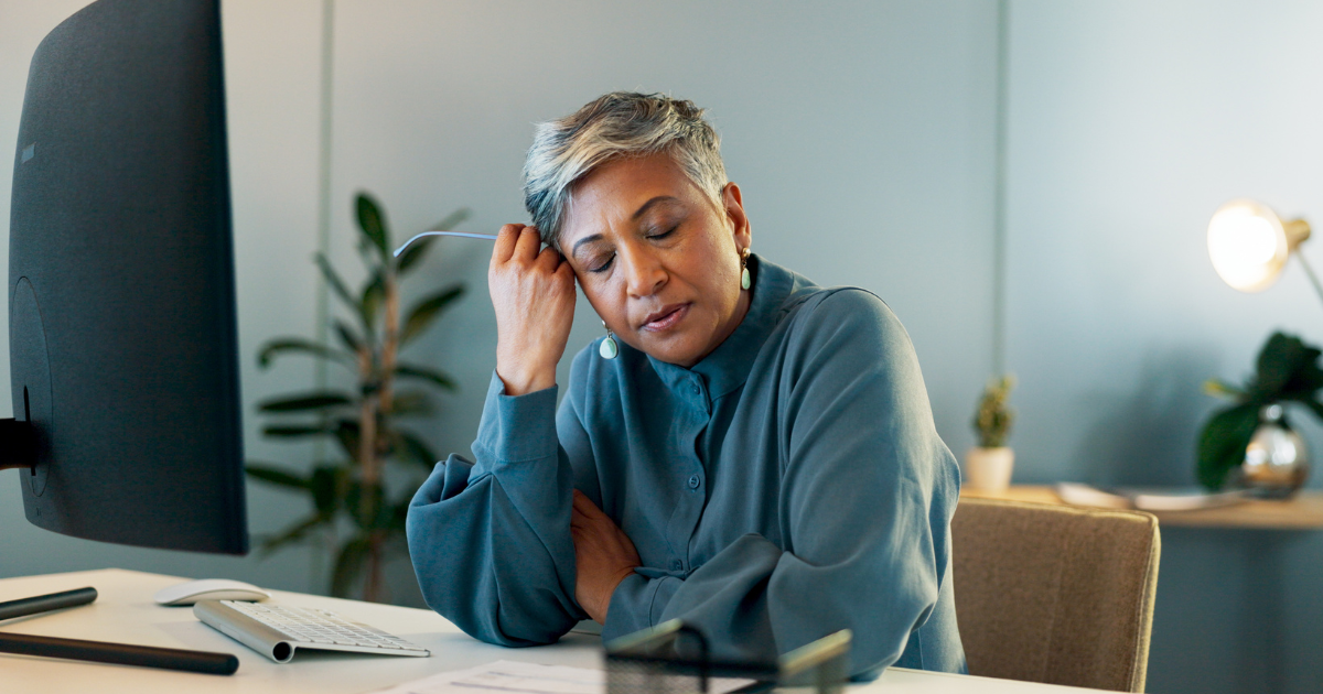 Middle-aged woman looking stressed at her desk
