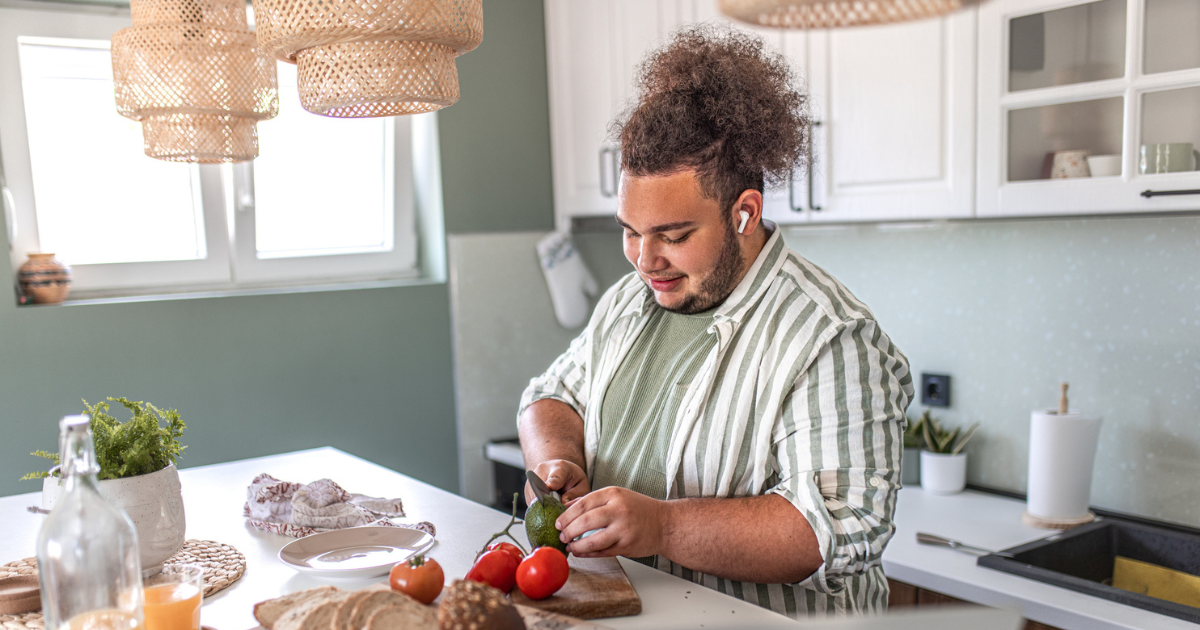 Man cutting avocado in kitchen