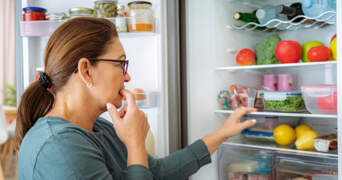 Woman looking at food in fridge