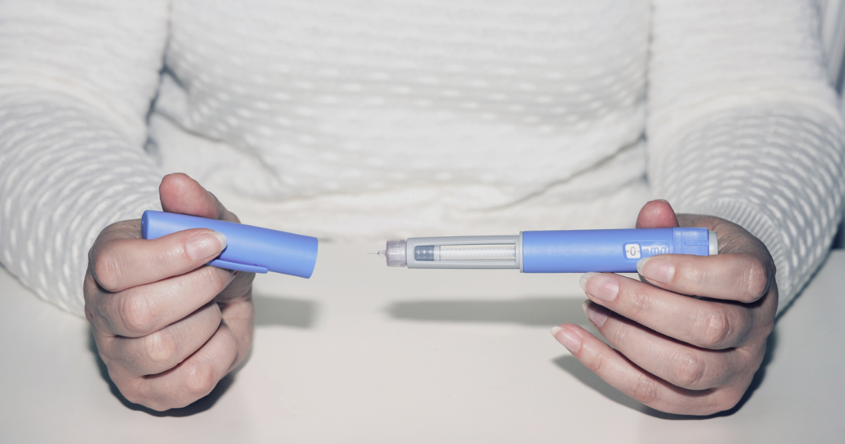 Close up of woman holding injection pen