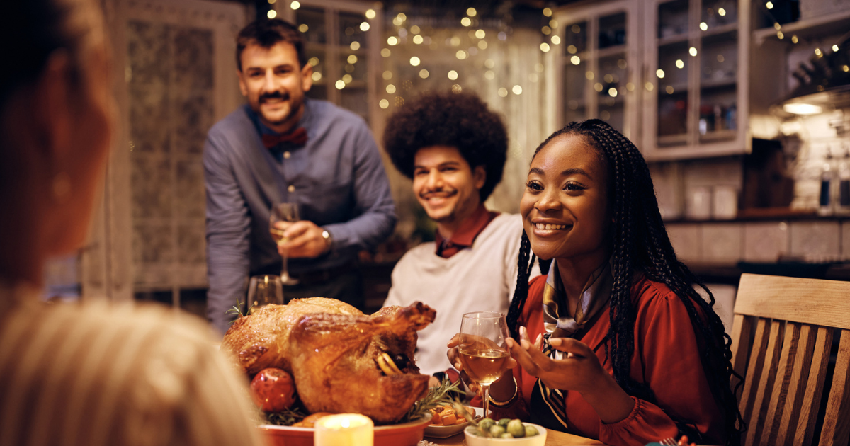 Family sitting around a table eating turkey