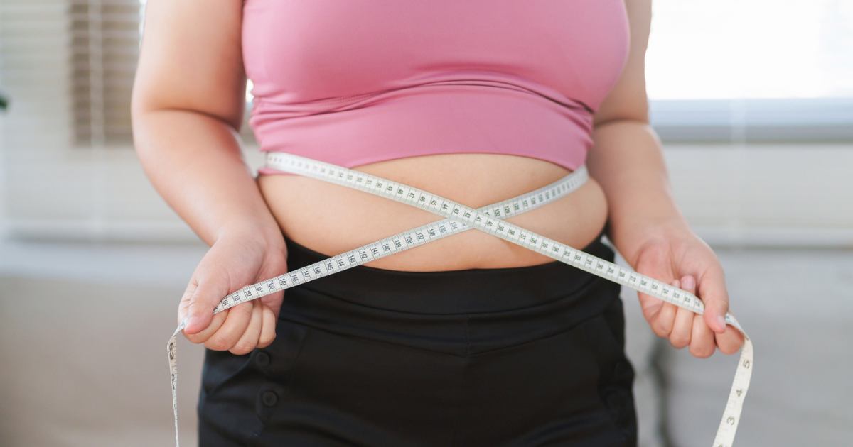 Close up of woman measuring her waist
