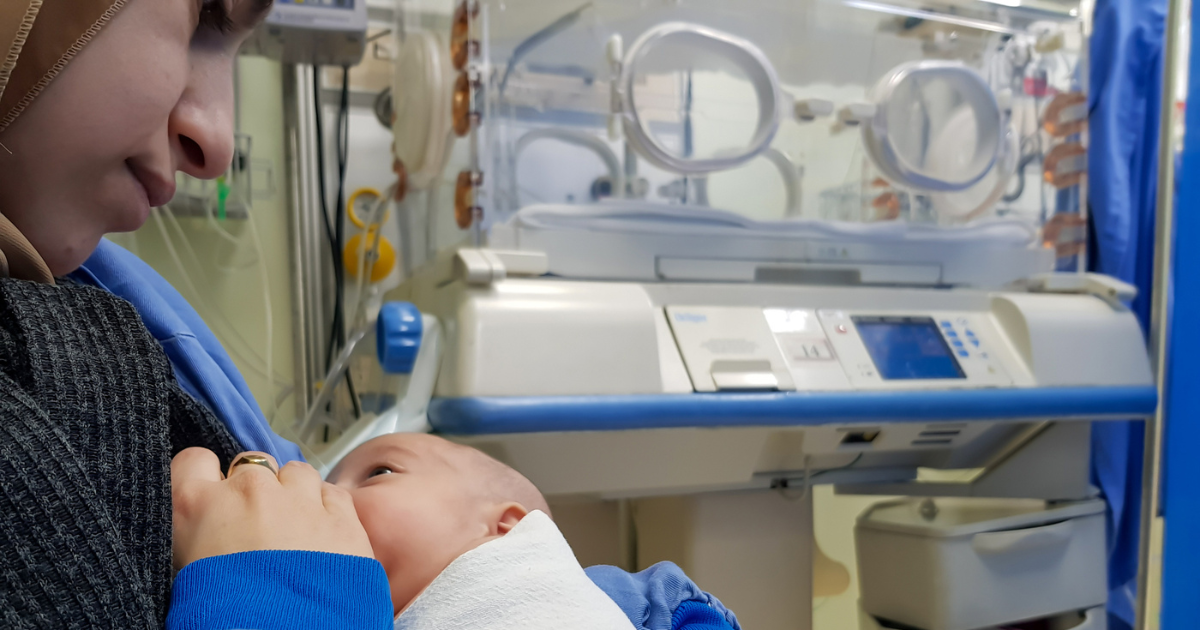 Mother breastfeeding her premature baby