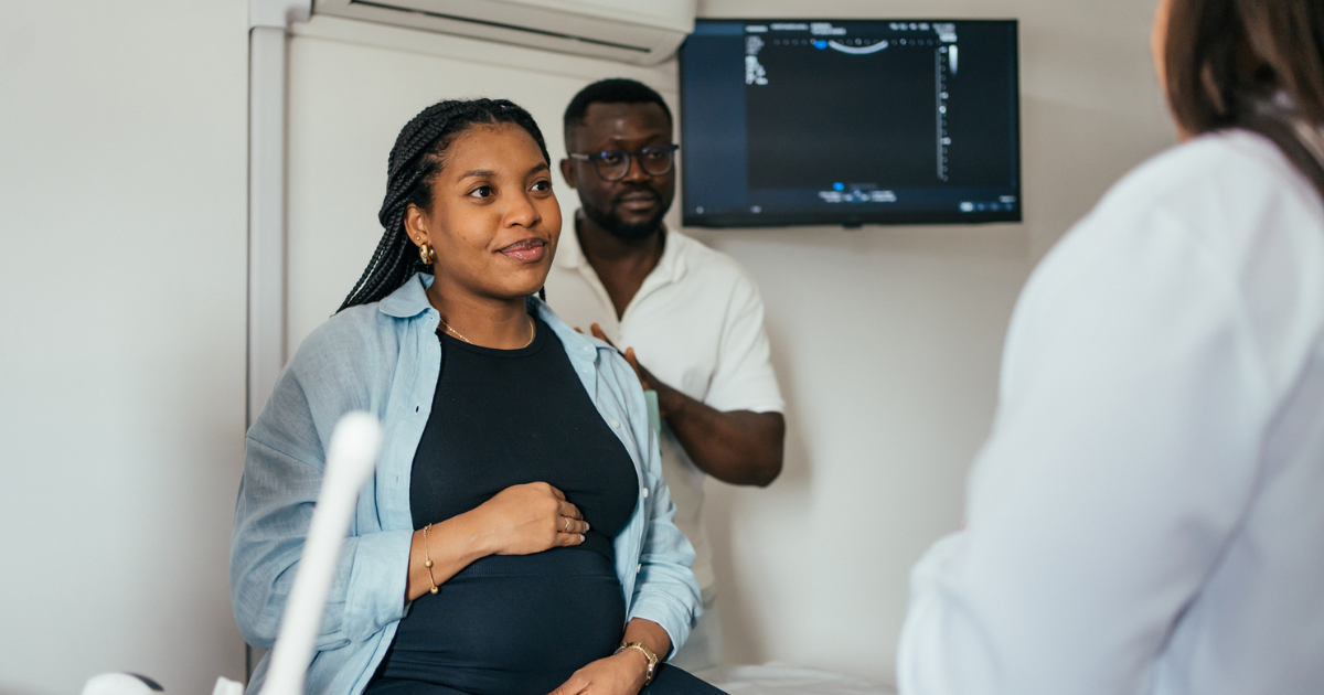 Pregnant woman and husband talking to doctor