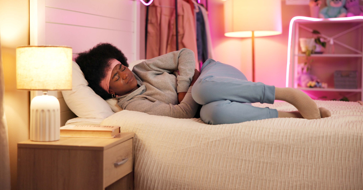 Woman with stomach pain lying in bed