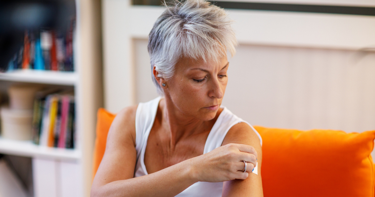 Woman putting patch on her arm
