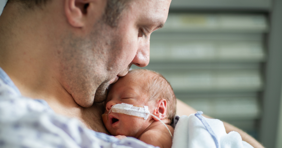 Dad holding infant in NICU