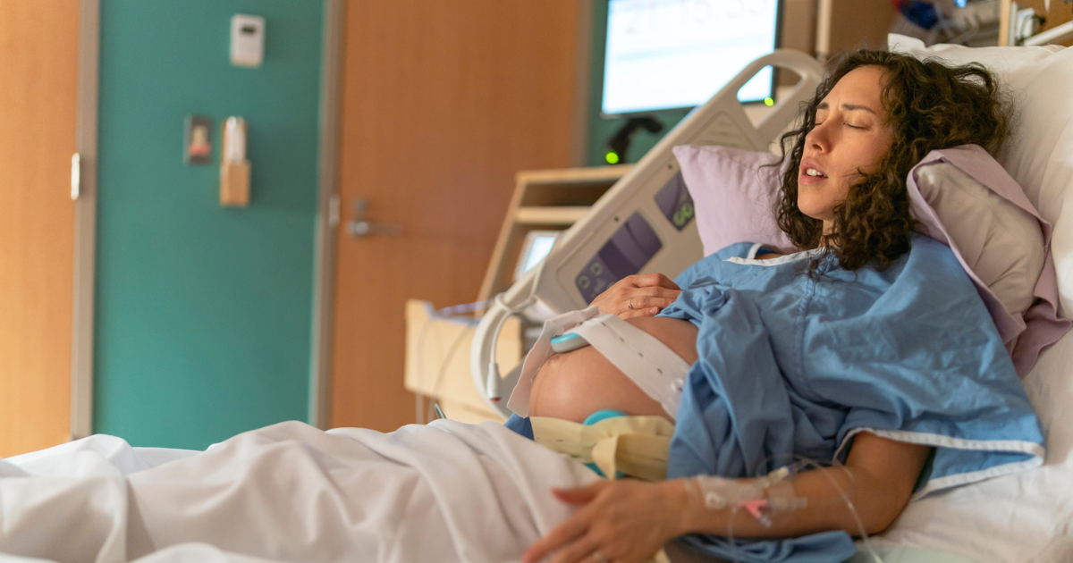 Pregnant woman in labor in hospital bed