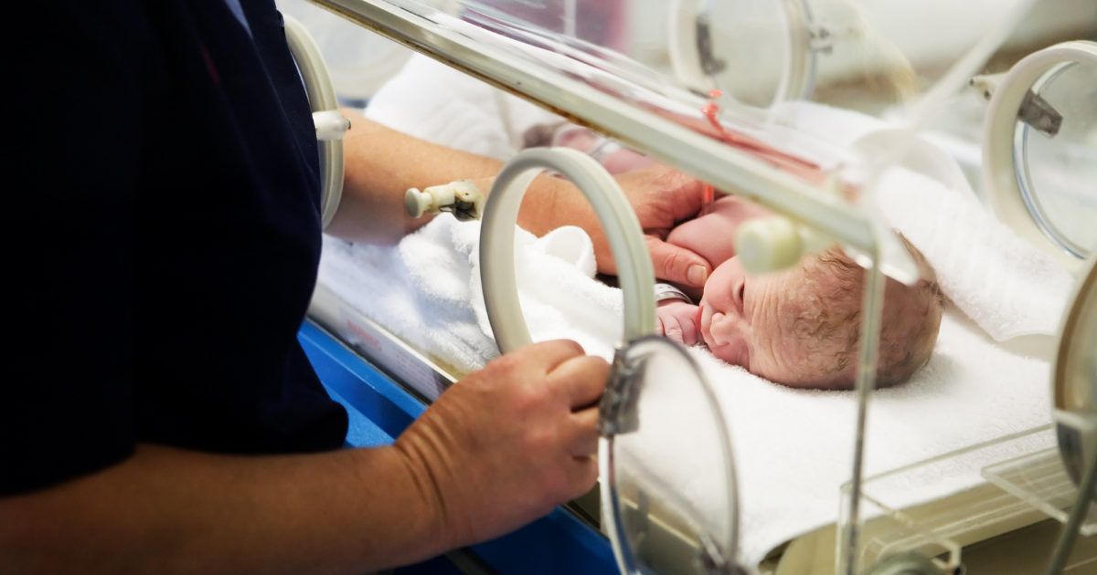 Nurse and newborn in incubator