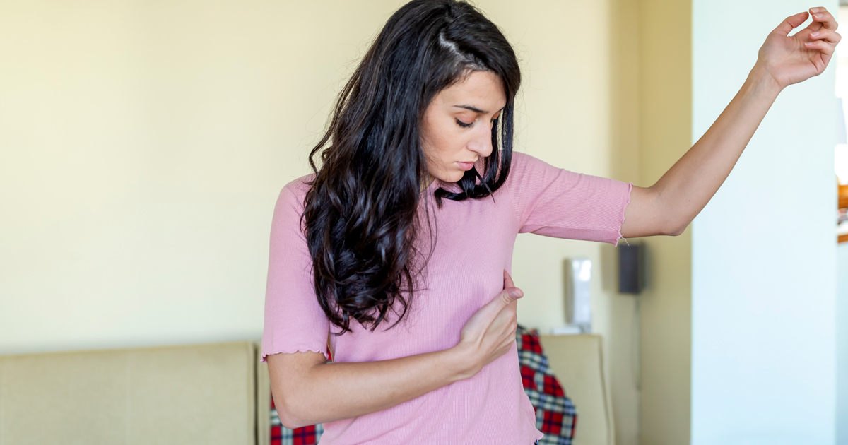 Woman performing a self breast exam