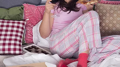 Woman eating pizza and drinking wine