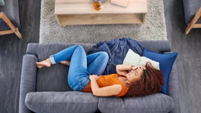 picture of a person on a couch clutching their stomach