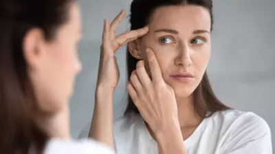 picture of a woman looking at her skin in the mirror