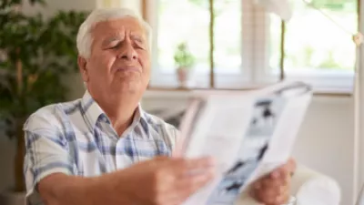 Older man squinting at a magazine
