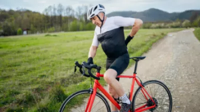 Older man on a bicycle with lower back pain