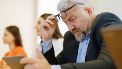 Man squinting at his tablet