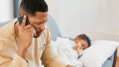 Father on the phone with sick child lying on the couch