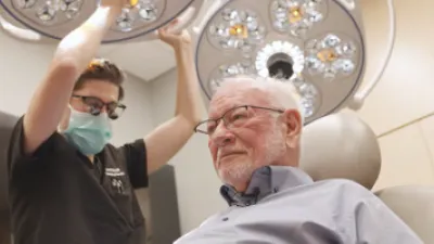 Dr. Sutton looking at Douglas Smith's scalp